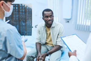 Black patient listening to doctors in a clinical setting, highlighting the importance of avoiding biased medical documentation