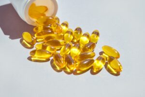 Bright yellow vitamin D or omega-3 capsule with sun shadow, symbolizing supplement overuse and testing trends