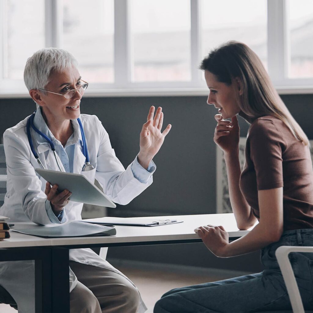 Doctor discussing treatment with a patient, illustrating why “ask your doctor” in drug ads influences prescribing