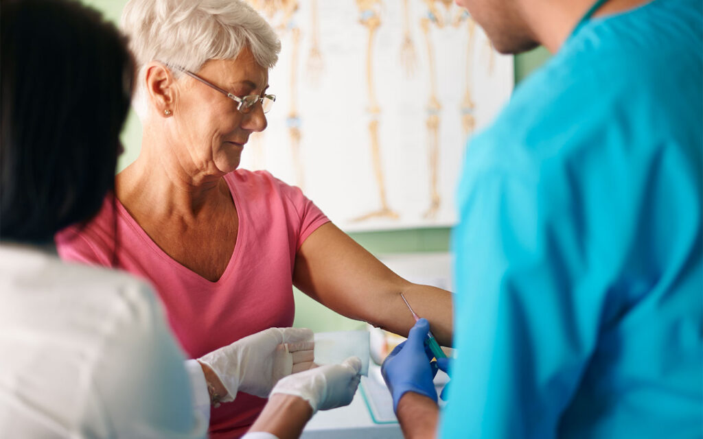 Older adult having blood drawn in a clinic, illustrating LDL cholesterol in older adults and why LDL targets differ from midlife