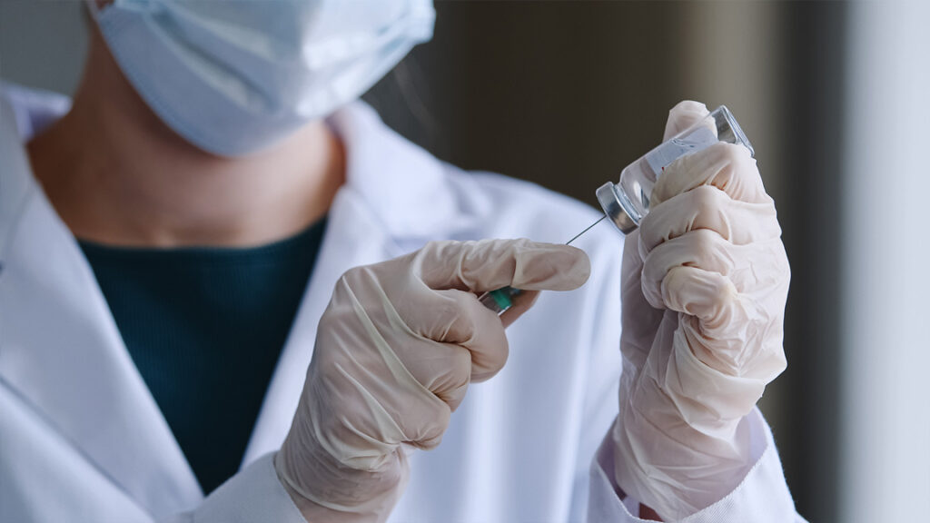 Clinician preparing a vaccine dose with a syringe, illustrating pneumococcal vaccine effectiveness and the pneumonia shot