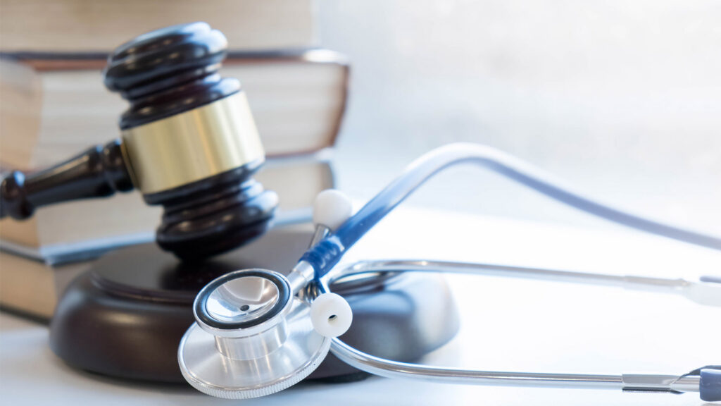 Gavel and stethoscope on a desk, illustrating a state medical board investigation and how medical policy and enforcement can shape care
