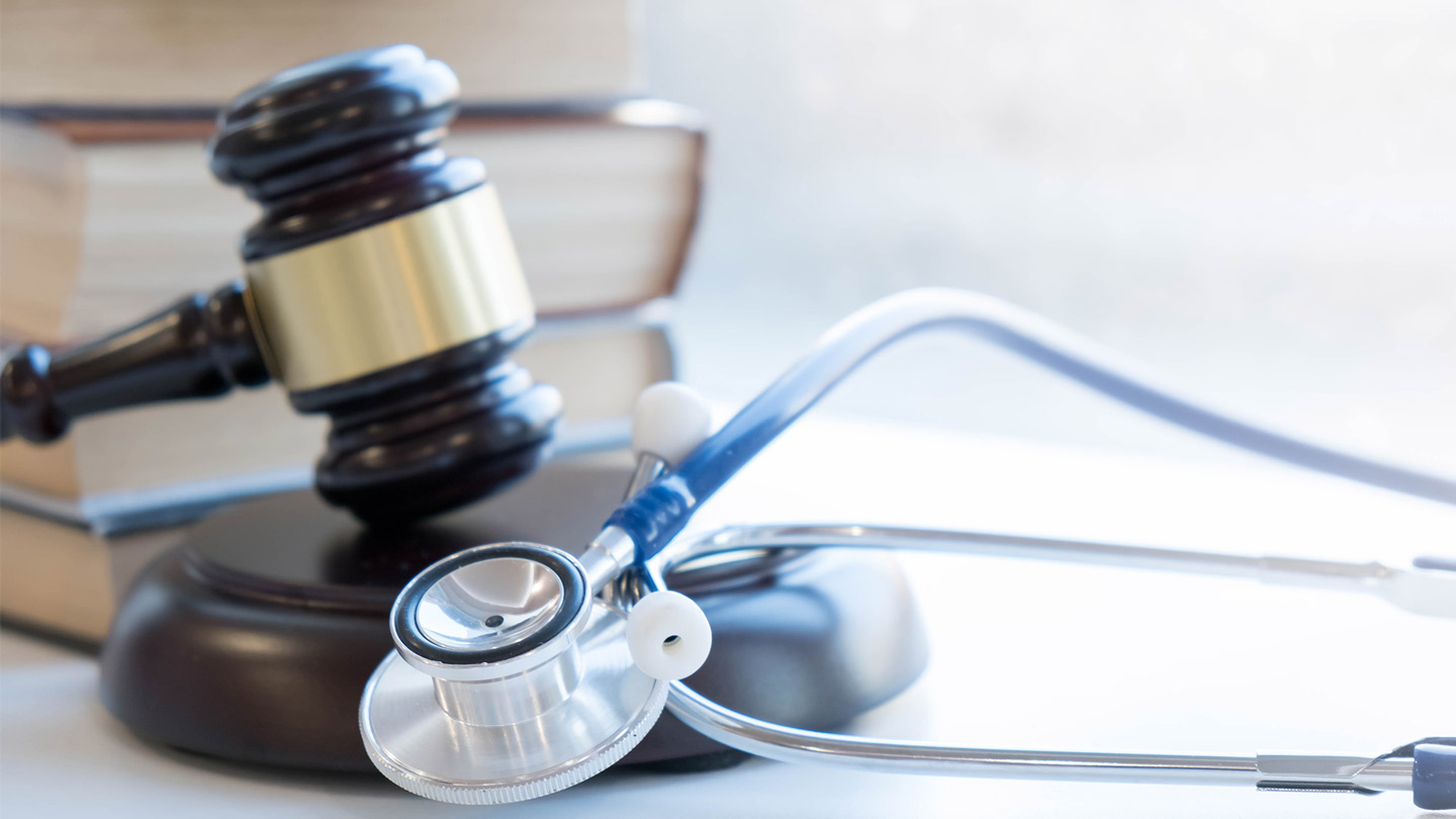 Gavel and stethoscope on a desk, illustrating a state medical board investigation and how medical policy and enforcement can shape care